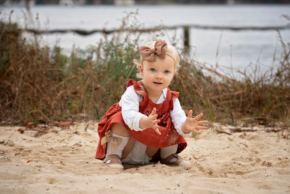 A toddler exploring the sandy shoreline