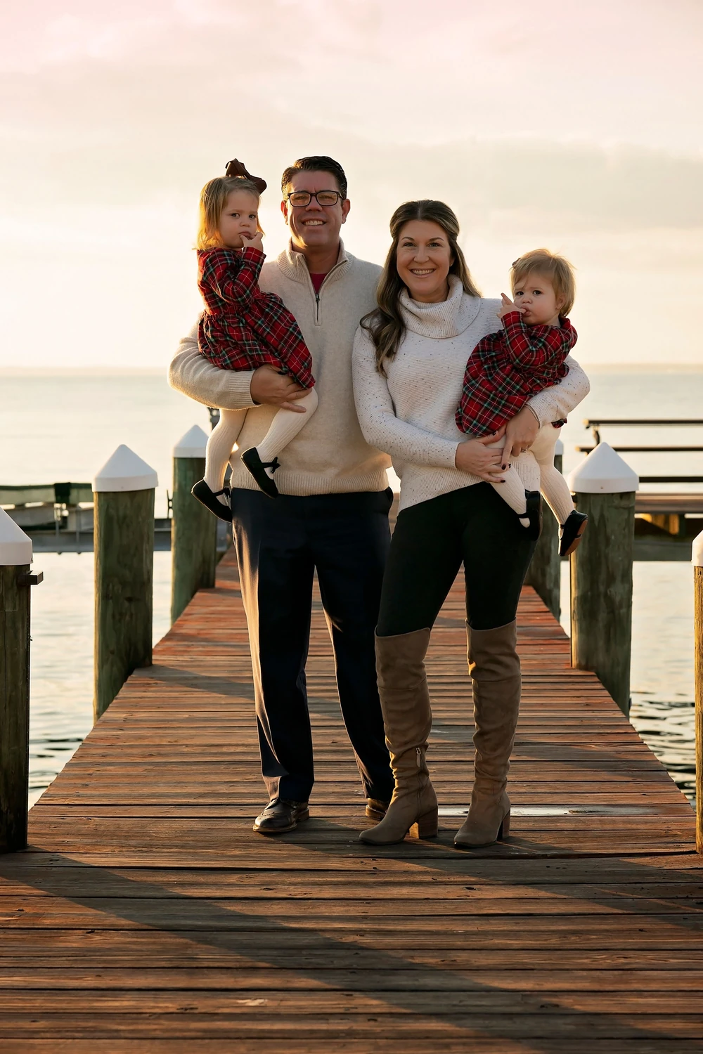 A family together on a dock at sunset