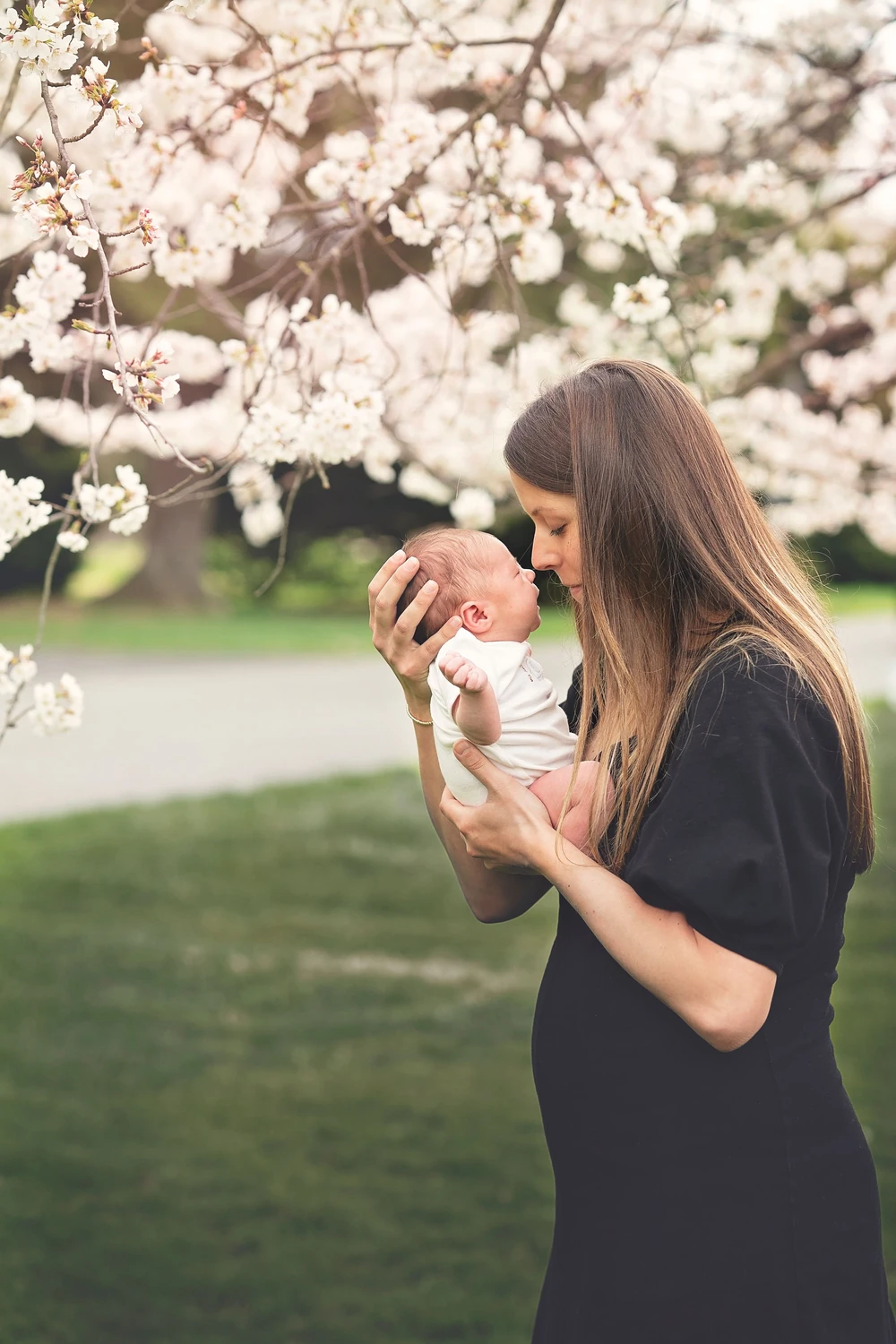 A mother and baby beneath a flowering tree