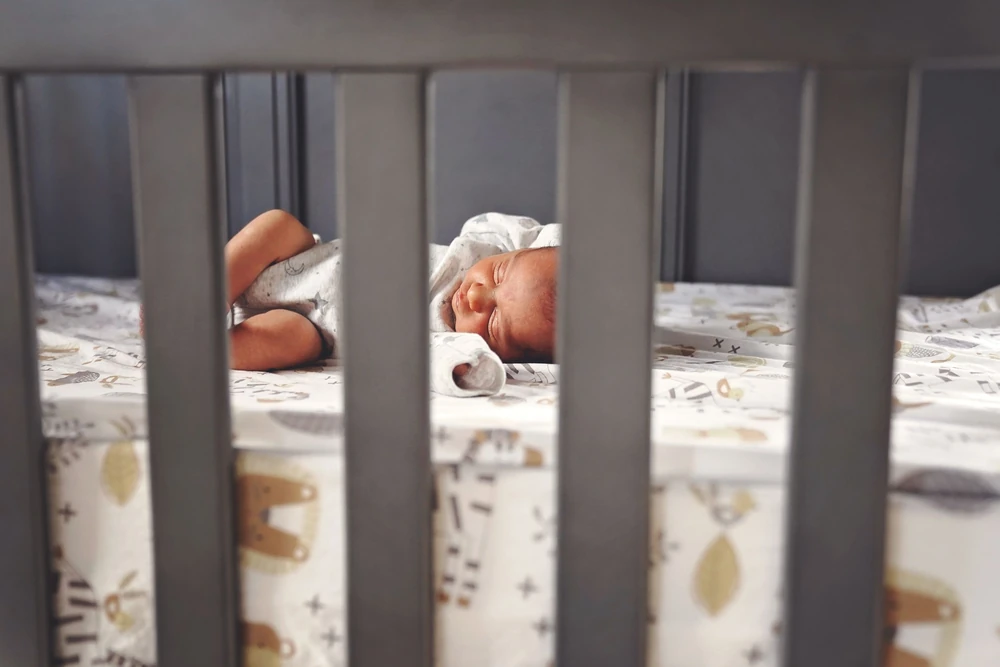 A newborn sleeping peacefully in a crib